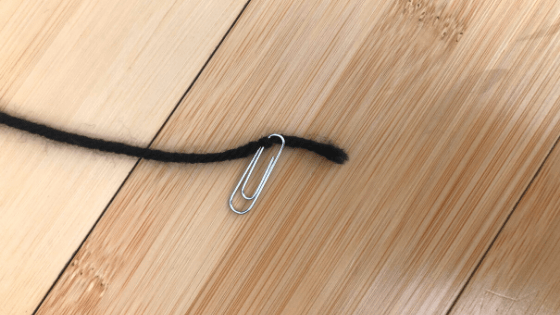 Slip paper clip through string