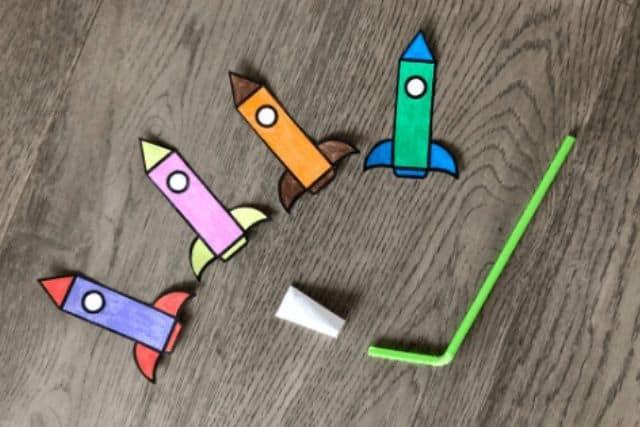 colored paper rocket attached to straw for launch