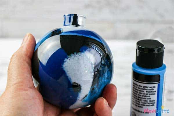 Add dark blue paint in plastic ornament balls