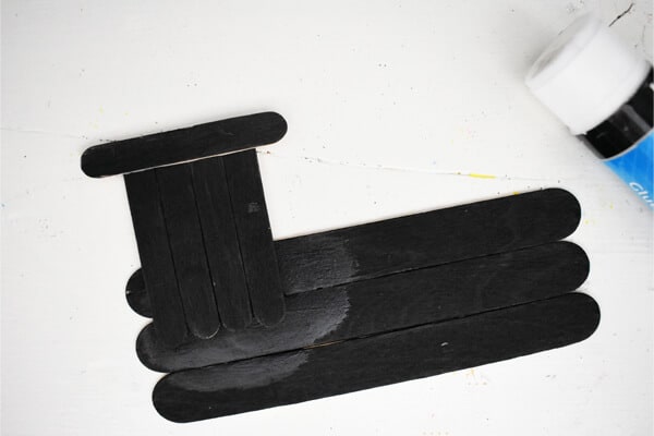 black acrylic paint done on craft sticks