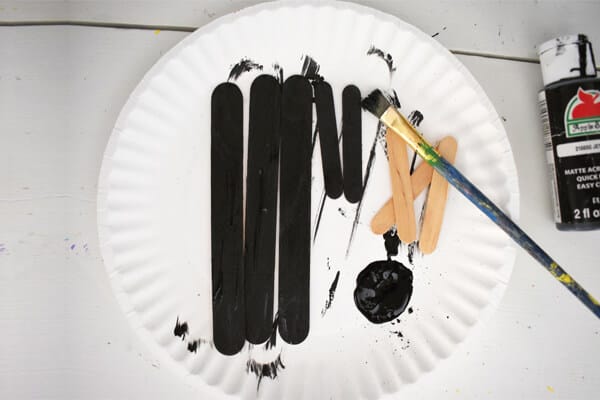 black acrylic paint on craft sticks