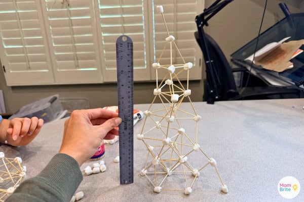 Measuring the marshmallow and toothpick tower with a ruler
