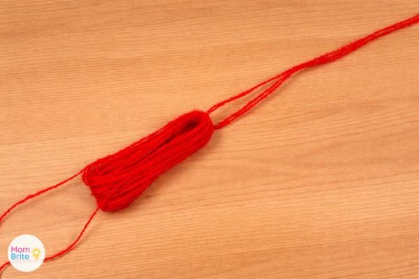 Red yarn bundle removed from cardboard and tied at the top