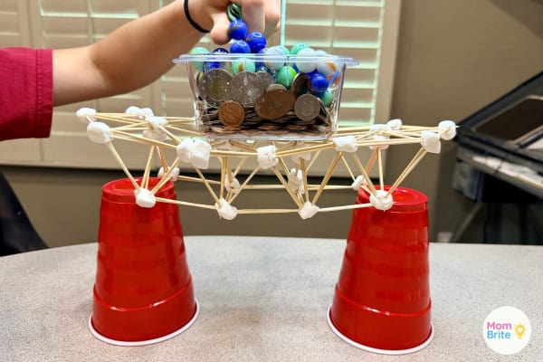 Marshmallow bridge with container full of coins and marbles